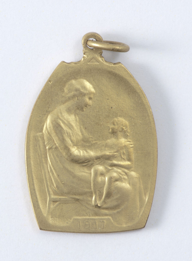 Goldmedaille mit Relief einer Frau in weißem Kleid mit Haarknoten, die ein Kind hält, beide schauen sich sanft an, beschriftet mit "Mutter und Kind."