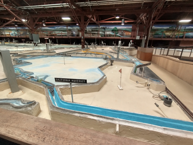Indoor-Wasserpark mit mehreren Rutschen, Deckenbeleuchtung, Wandgemälden und einem Minigolfplatz.