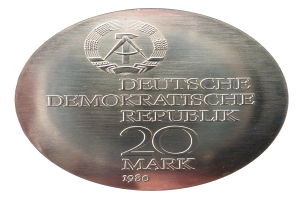 Eine Silbermedaille mit der Aufschrift "Deutsche Demokratische Republik" auf weißem Hintergrund.