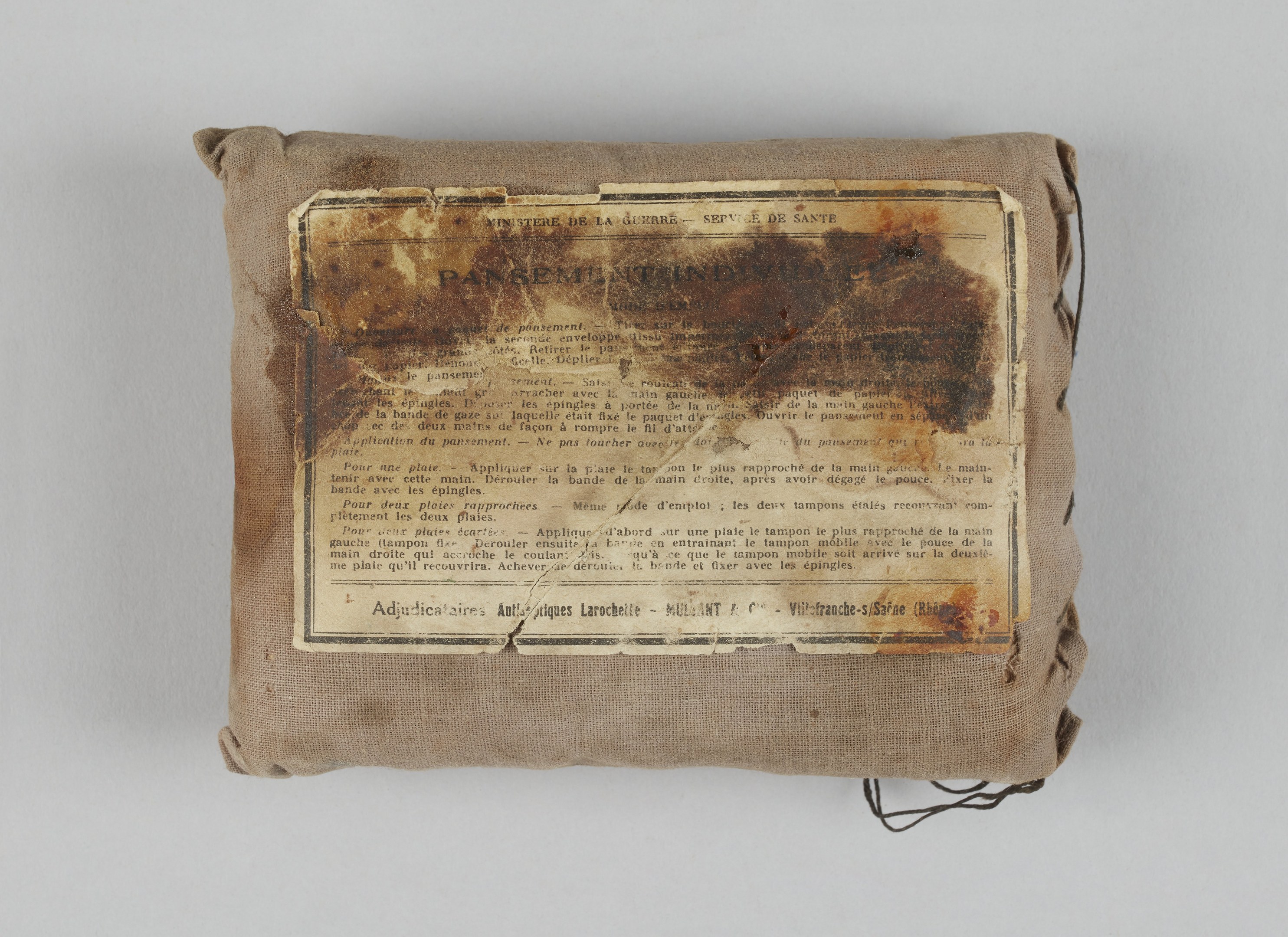 Kleiner Verbandskoffer mit einer Papierliste seiner Inhalte oben drauf.