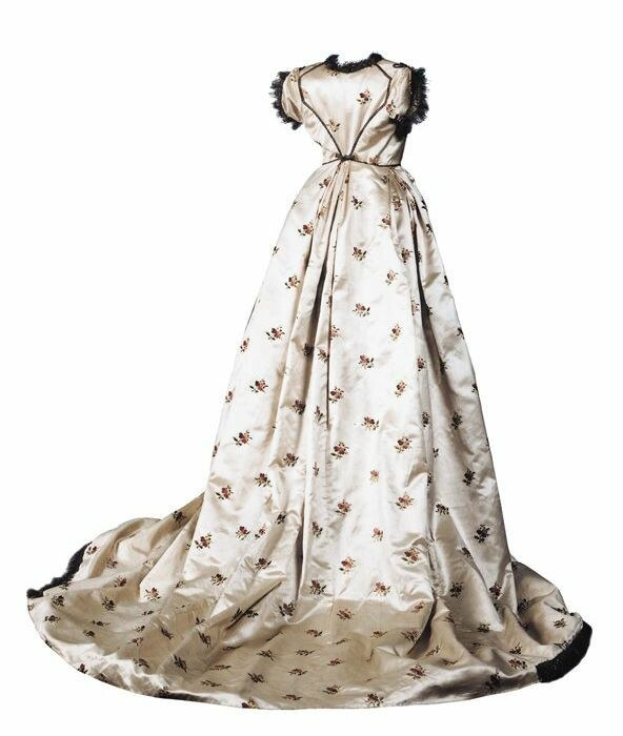 Weißes 18. Jahrhundert Hochzeitskleid mit schwarzem Saum, Herzausschnitt und zarter floraler Stickerei auf einem voluminösen Rock gegen einen weißen Hintergrund.