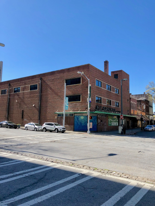 Leere Straße mit parkenden Autos am Straßenrand, Laternenpfähle, Schilder und Gebäude mit Fenstern, Bäume und ein klarer blauer Himmel im Hintergrund, kommerzielles Grundstück zum Verkauf an 715 W Main St, Chicago, Illinois 60611, USA Wassermarkierung unten.