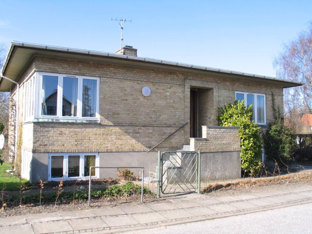 Zweizimmer-Detached-Bungalow zum Verkauf in St Johns Wood, Swindon, mit Dach, Fenstern, Tör, Treppe, Metallzaun, Pflanzen, Gras, Bäumen, Satellitenschössel und bewölktem Himmel.