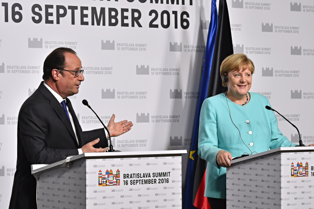 Bundeskanzlerin Angela Merkel und Frankreichs Präsident François Hollande stehen an Rednerpulten mit Mikrofonen, sie lächeln, mit einem "Bratislava-Gipfel 2016"-Schild hinter ihnen.