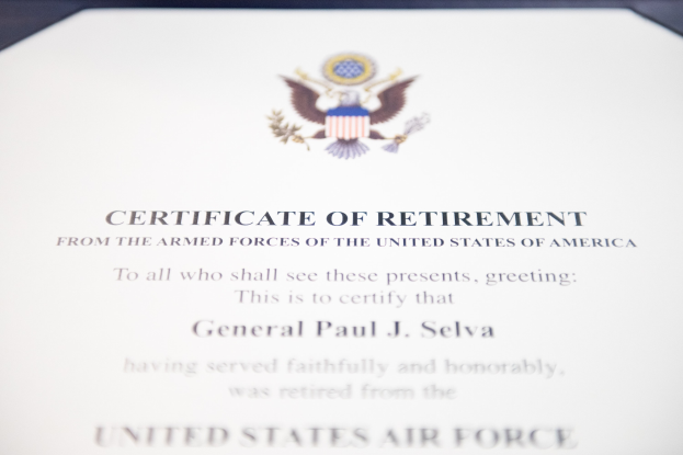 Rahmenurkunde zur Verabschiedung von der United States Air Force mit blauem Rand, zentralem Sternschild-Logo innerhalb eines Lorbeerkranzes und einer 'Verabschiedung'-Banderole, alles in schwarzer Tinte auf weißem Papier.