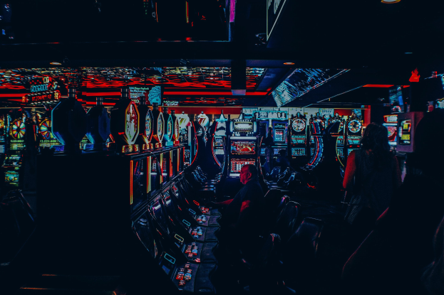 Menschen an Spielautomaten in einem hell erleuchteten Casino.
