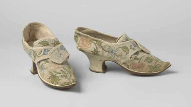 Ein Paar Frauen-Low-Heels mit gerundeten Zehen, mit floraler Stickerei in Rosa, Lila und Grün auf einer weißen Oberfläche.