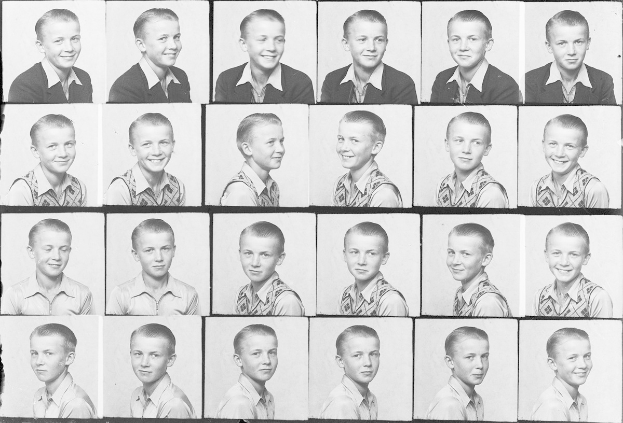 Ein Schwarz-Weiß-Foto eines strahlenden jungen Jungen mit ordentlich gekämmtem Haar und hellen, fröhlichen Augen.