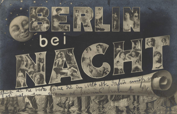 Schwarzes und weißes Foto einer Gruppe von Menschen, die vor einem "Berlin Bei Nacht"-Schild feiern, mit einem Mond im Hintergrund, das Schild mit Sternen und Streifen geschmückt.